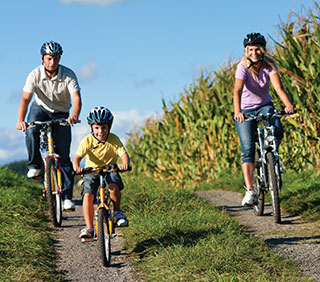 family-cycling-past-fields