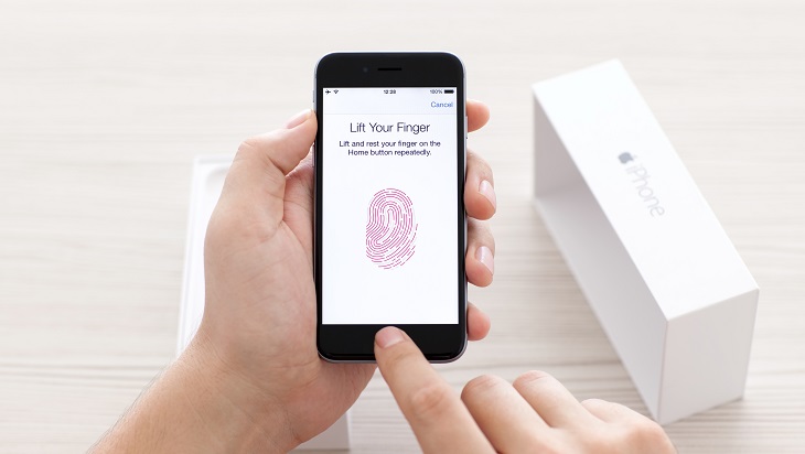 Man scans the fingerprint sensor Touch ID on iPhone 6