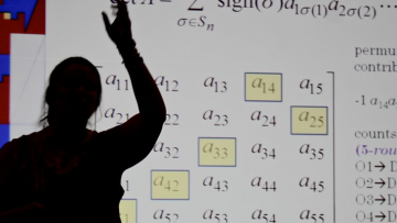 teacher in front of projector display