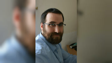 Eduard turning towards the camera. against a light background.