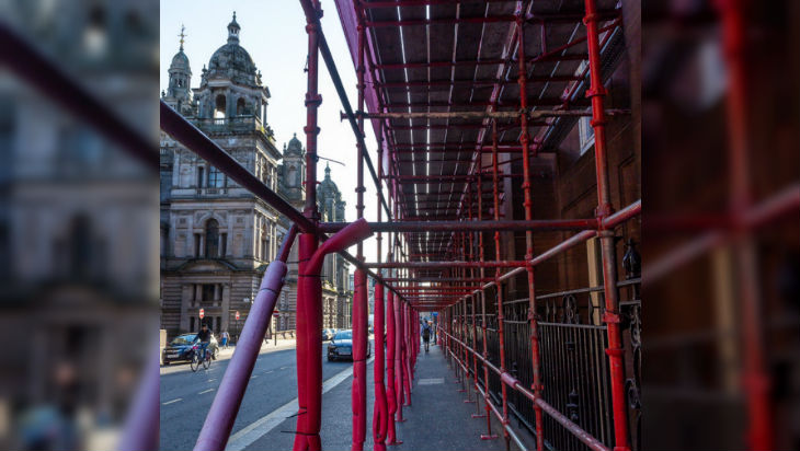 A path surrounded on all sides by scaffolding which is covered in red foam insulation