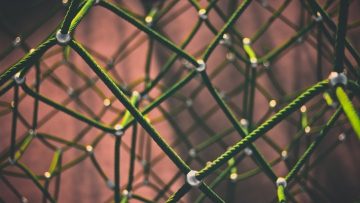 An abstract image of yellow ropes connected with white balls.