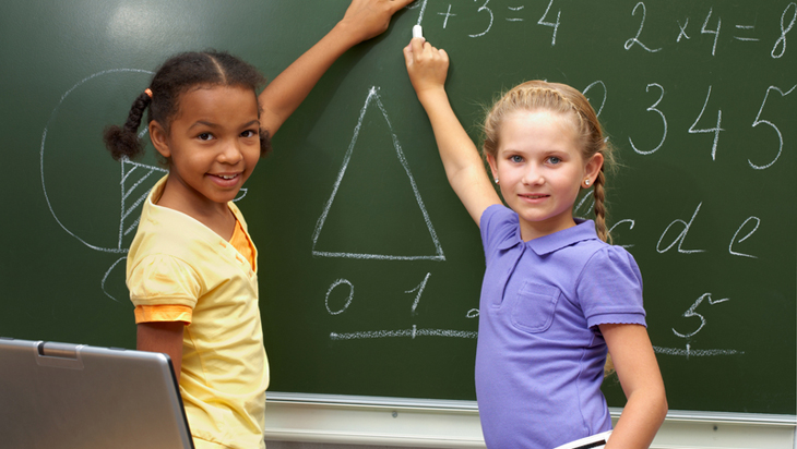 Two girls in front of chalkboard